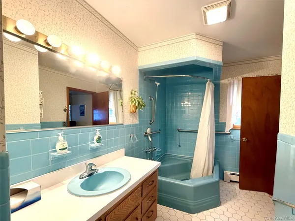 a bathroom with a sink vanity granite tub shower and a mirror