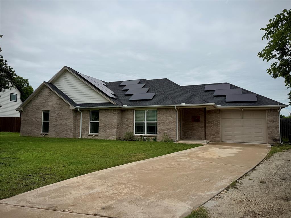 619 Mansfield Road Cleburne, TX 76031 - Photo 17 of 19 Brick exterior with a dark shingled roof featuring solar panels