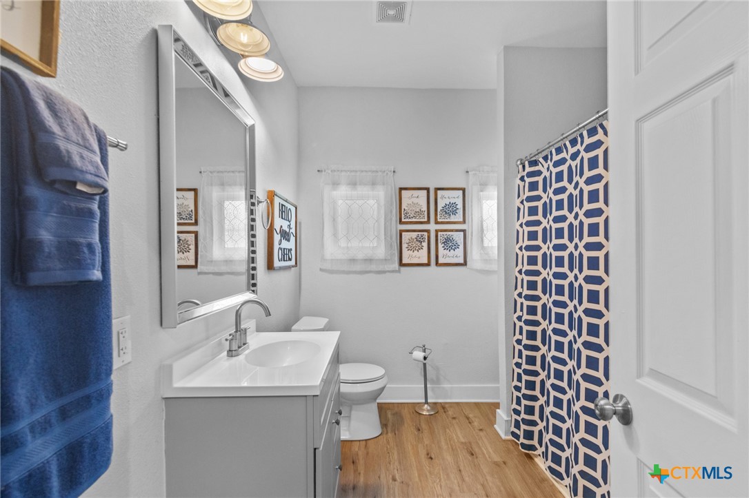 905 North Navarro Street Victoria, TX 77901 - Photo 17 of 28 a bathroom with a sink mirror and vanity