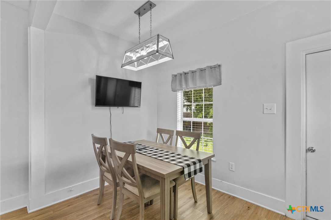 905 North Navarro Street Victoria, TX 77901 - Photo 18 of 28 a view of a dining room with furniture a chandelier and wooden floor