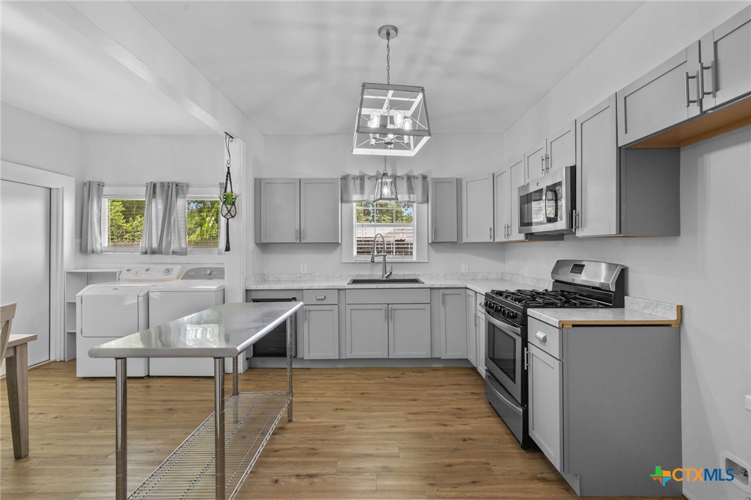 905 North Navarro Street Victoria, TX 77901 - Photo 20 of 28 a kitchen with stainless steel appliances granite countertop wooden cabinets a stove a sink and a refrigerator