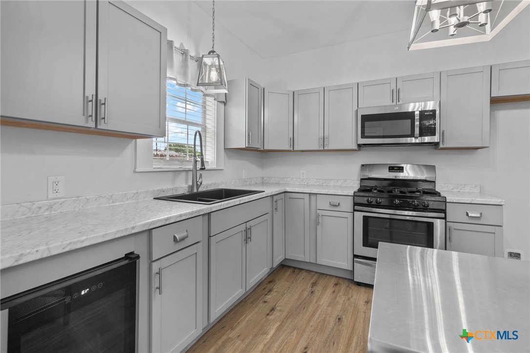 905 North Navarro Street Victoria, TX 77901 - Photo 23 of 28 a kitchen with stainless steel appliances granite countertop a sink dishwasher a stove and a microwave oven with cabinets