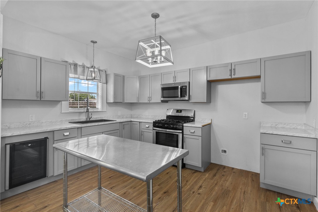 905 North Navarro Street Victoria, TX 77901 - Photo 24 of 28 a kitchen with stainless steel appliances granite countertop a sink stove and refrigerator