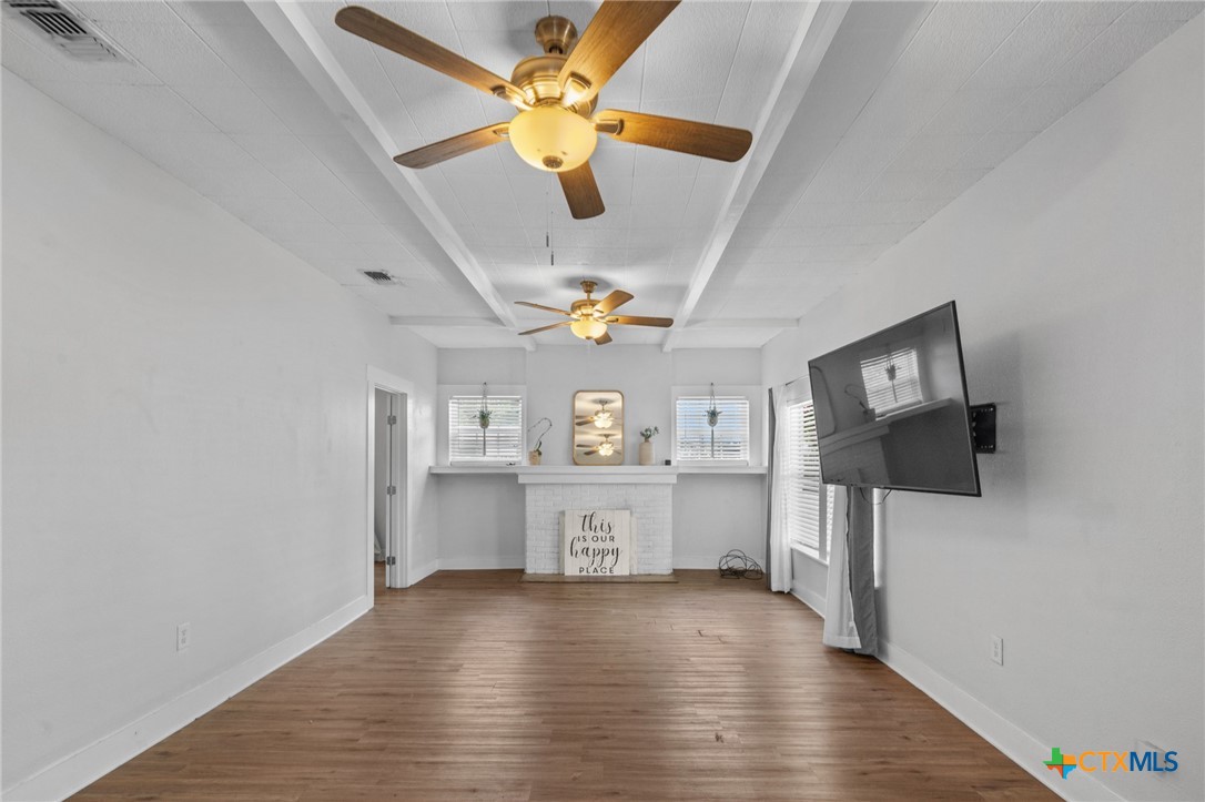 905 North Navarro Street Victoria, TX 77901 - Photo 10 of 28 a view of a kitchen with wooden floor a sink a refrigerator and window