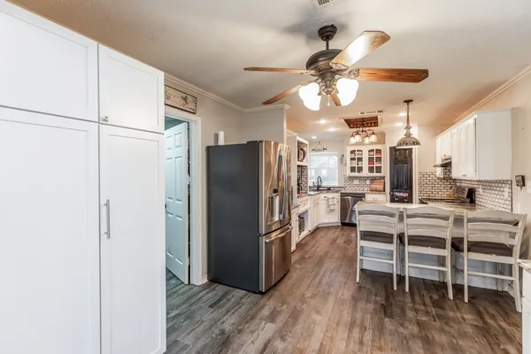 a view of a kitchen with dining table and stainless steel appliances
