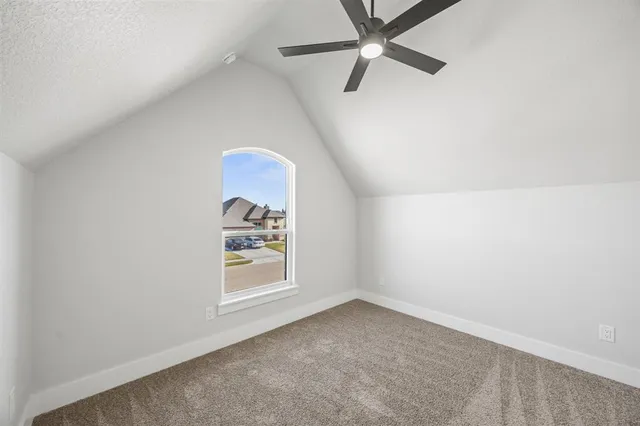an empty room with windows and ceiling fan