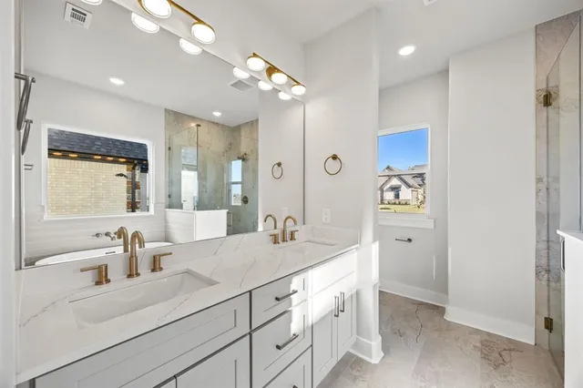 a bathroom with a sink double vanity granite and a mirror