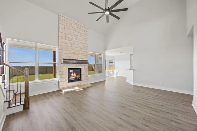 a view of a livingroom with a fireplace a ceiling fan and brick wall