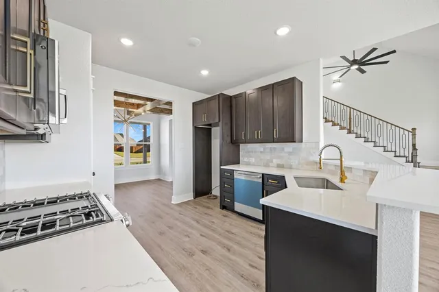 a kitchen with stainless steel appliances granite countertop a sink stove and refrigerator