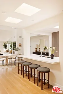 a dining hall with stainless steel appliances a dining table and chairs with wooden floor