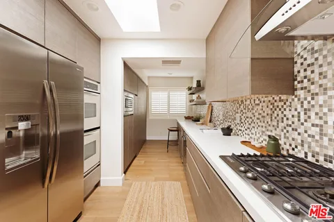 a kitchen with stainless steel appliances granite countertop a refrigerator and a stove