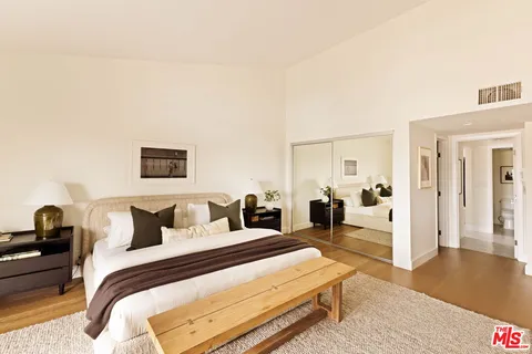 a bedroom with a bed and wooden floor