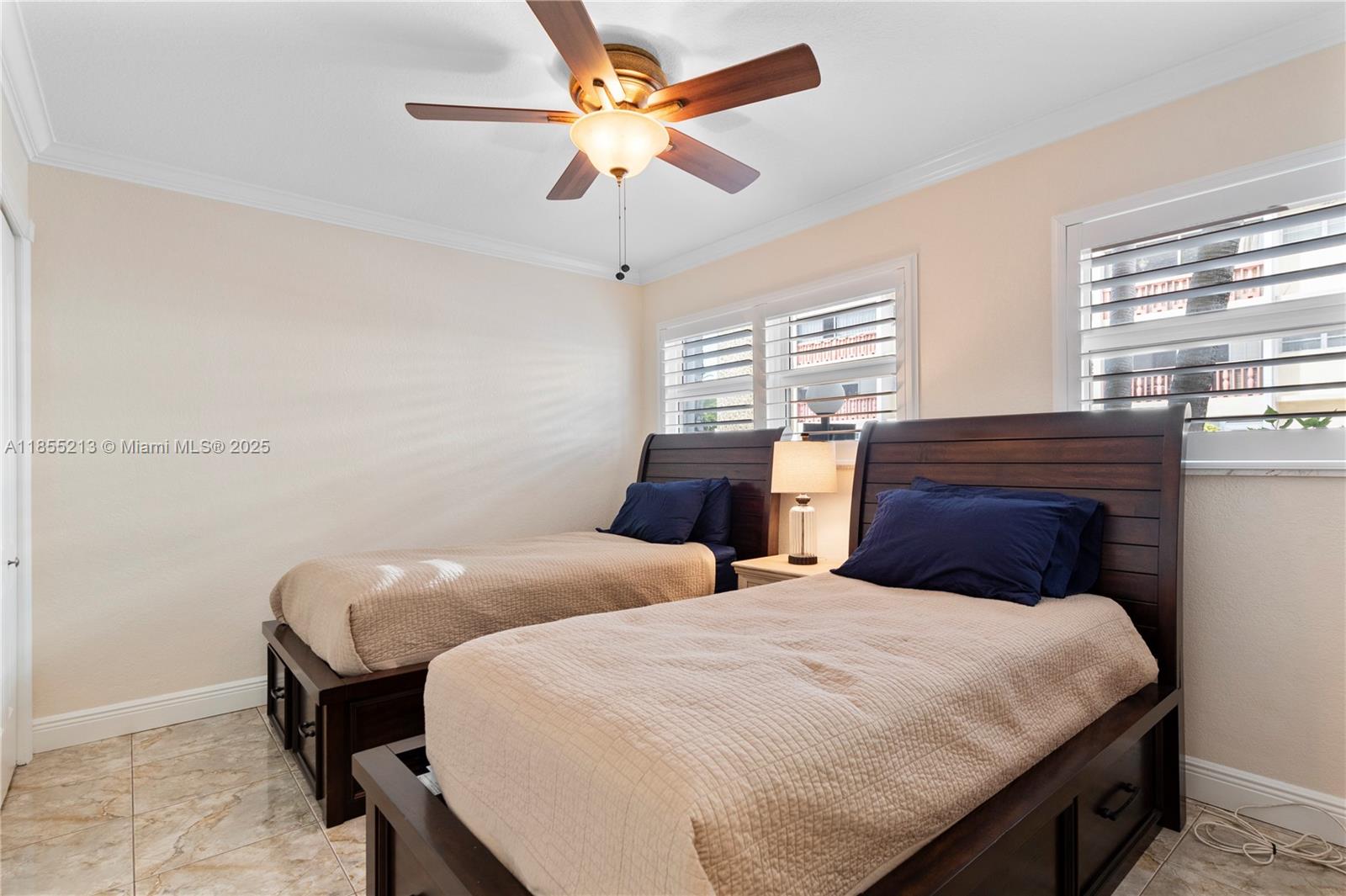 329 Southeast 3rd Street, Unit 105T Hallandale Beach, FL 33009 - Photo 18 of 25 a bedroom with two beds and a chandelier