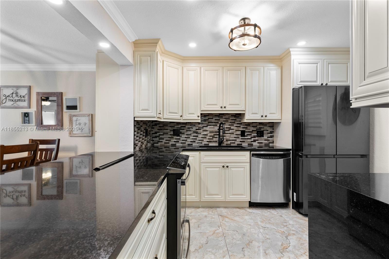 329 Southeast 3rd Street, Unit 105T Hallandale Beach, FL 33009 - Photo 4 of 25 a kitchen with stainless steel appliances granite countertop a refrigerator a stove and white cabinets with wooden floor