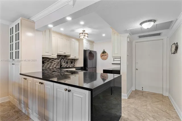 a kitchen with stainless steel appliances granite countertop a sink refrigerator and cabinets