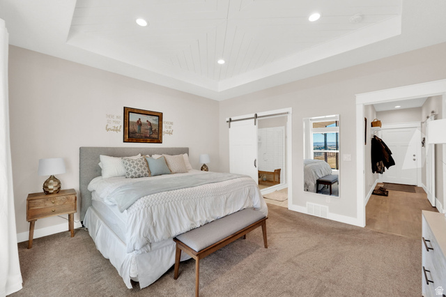 352 East Boulderville Road Oakley, UT 84055 - Photo 21 of 62 Carpeted bedroom featuring a barn door, recessed lighting, ensuite bathroom, and a tray ceiling