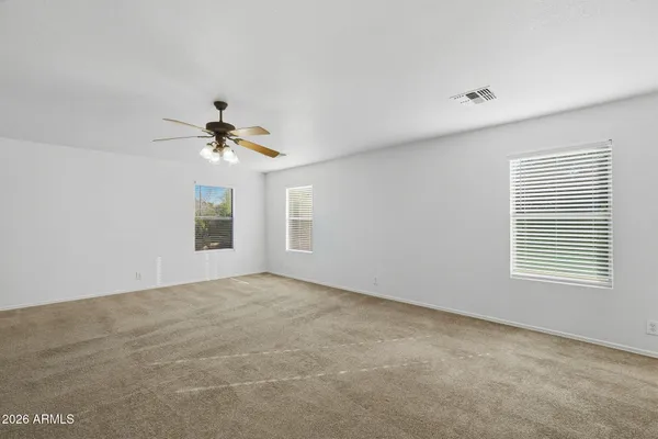 a view of an empty room with a chandelier fan