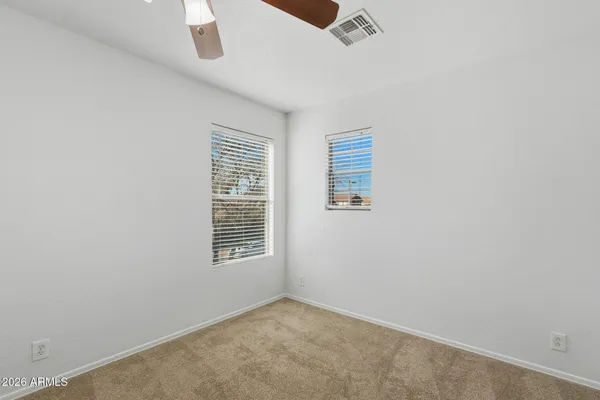 an empty room with windows and fan