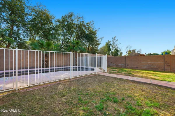 a view of a house with a small yard and wooden fence
