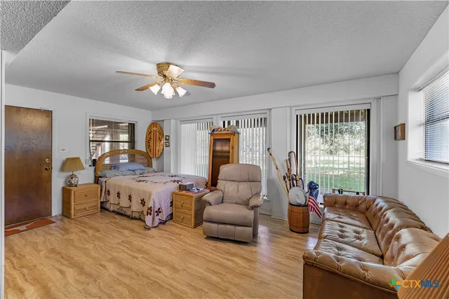 a kitchen with stainless steel appliances a refrigerator a stove a dining table and chairs with wooden floor