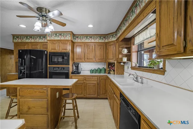 a kitchen with stainless steel appliances granite countertop a refrigerator and a stove
