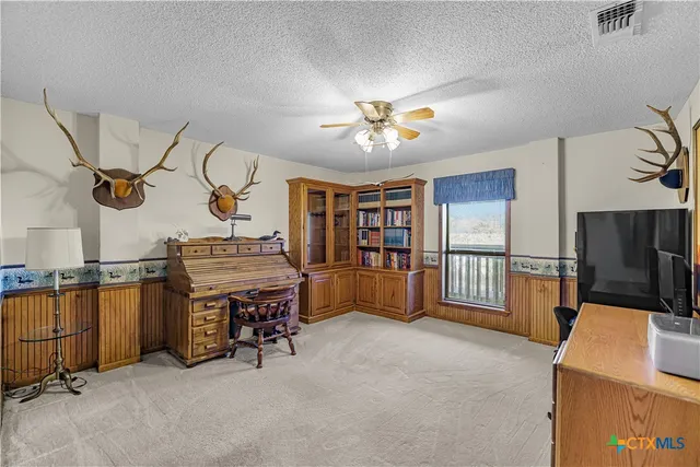 a spacious bedroom with a bed and a chandelier