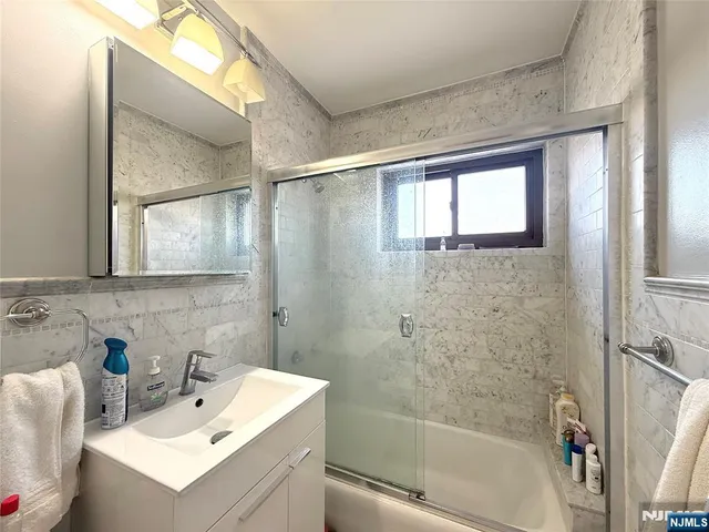 a bathroom with a sink mirror and a bathtub