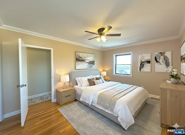 a bedroom with a large bed a chandelier and windows