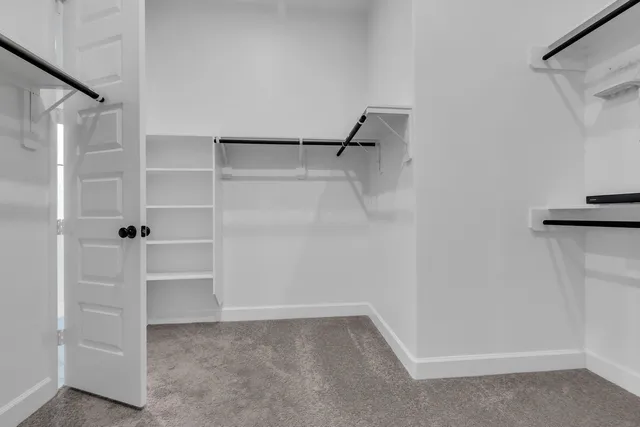 a view of walk in closet with empty racks