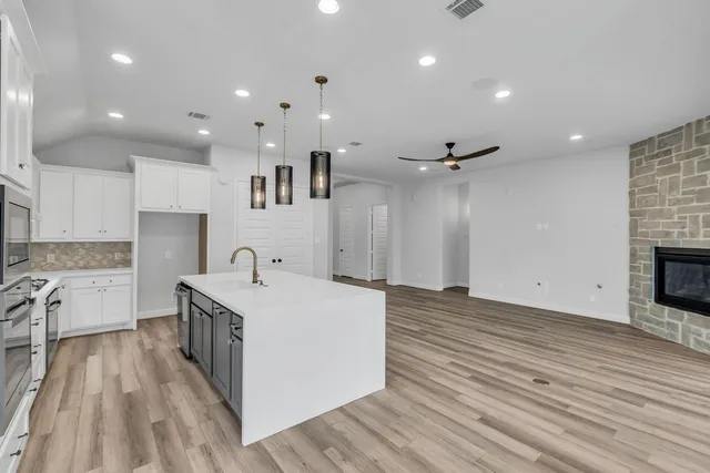 a large white kitchen with a sink a stove and a refrigerator