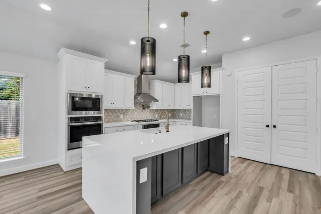 a kitchen with a sink a stove and cabinets