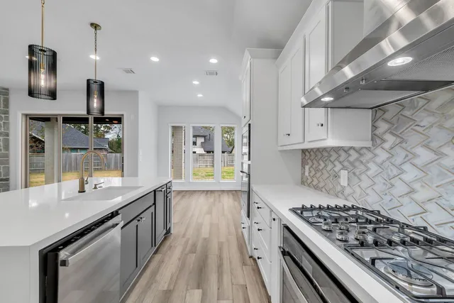 a kitchen with stainless steel appliances granite countertop a stove and a sink