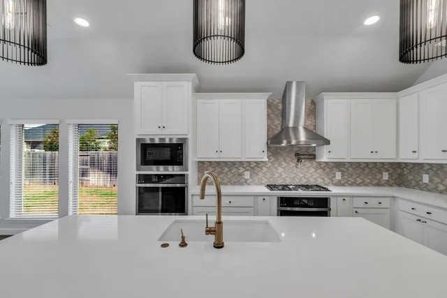 a kitchen with stainless steel appliances a stove a refrigerator and a sink