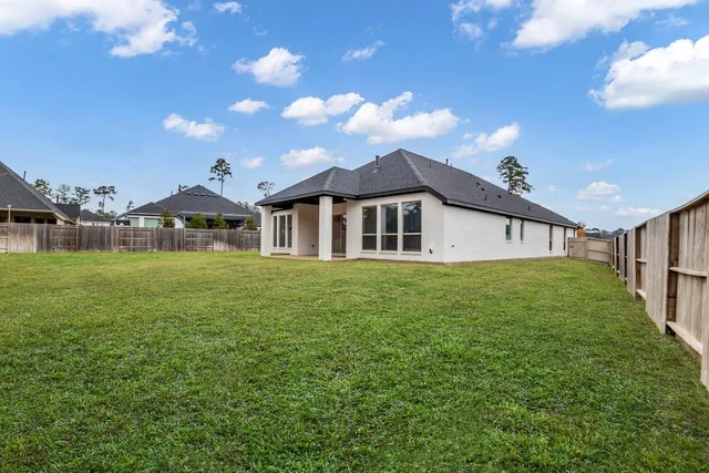 a view of a house with backyard and a tree