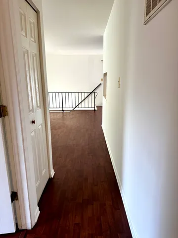 a view of a hallway with wooden floor and staircase