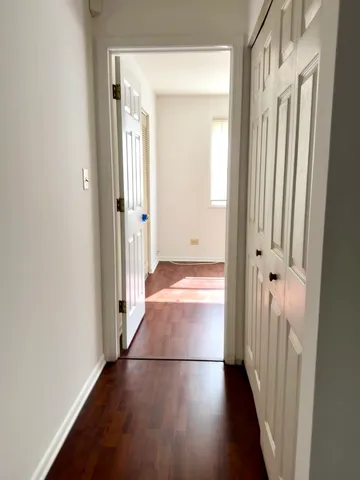 a view of a hallway with wooden floor and staircase