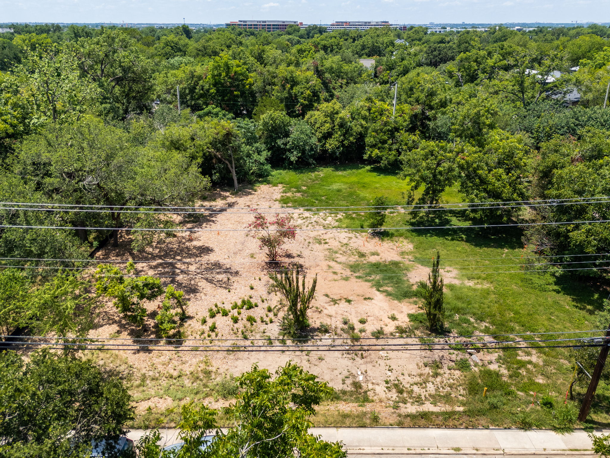 4801 Ledesma Road Austin, TX 78721 - Photo 22 of 24 A spacious, cleared lot ready for your custom build, nestled among mature trees with a distant urban view.