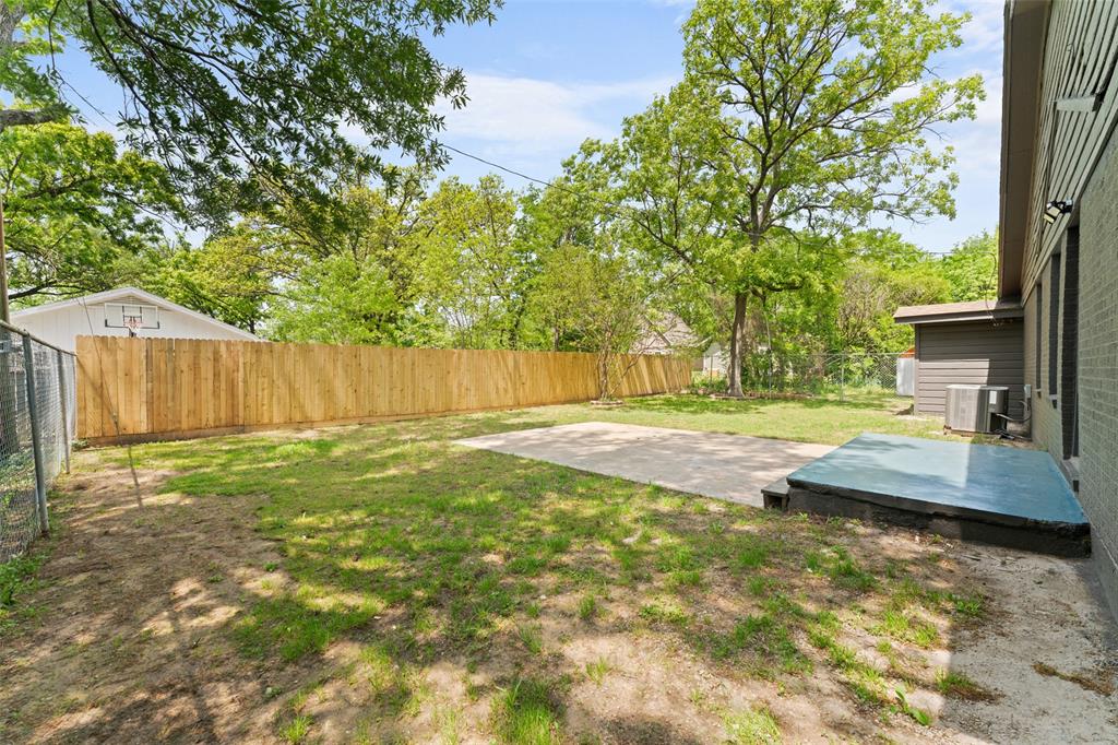 2405 Monroe Street Commerce, TX 75428 - Photo 29 of 31 a view of a backyard with table and chairs and wooden fence