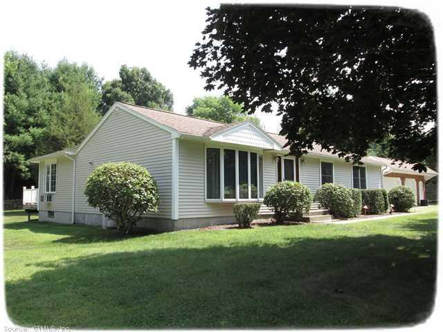 a front view of a house with a garden and yard