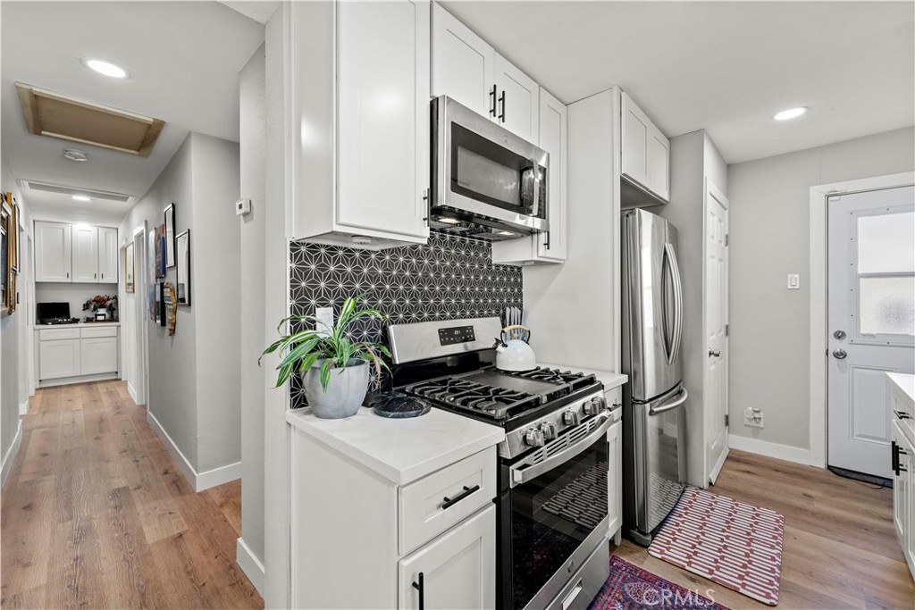 2117 West Corydon Street Compton, CA 90220 - Photo 10 of 40 a kitchen with stainless steel appliances a refrigerator a stove a microwave and cabinets