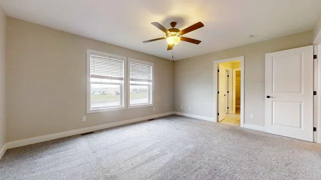 a view of an empty room with a ceiling fan