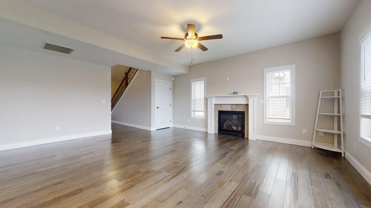 1318 Myrtle Beach Avenue Champaign, IL 61822 - Photo 5 of 29 an empty room with wooden floor fireplace and windows