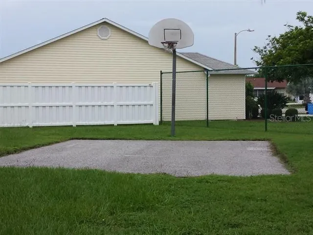 a white house with a small yard and wooden fence