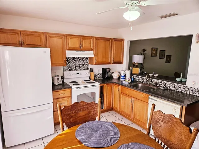 a kitchen with stainless steel appliances granite countertop a refrigerator a sink a stove and a microwave