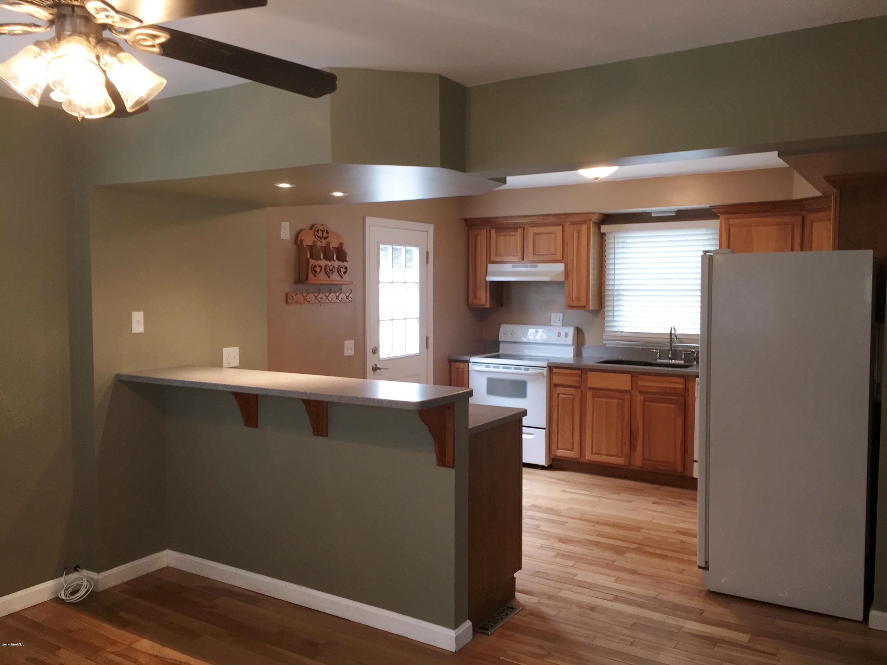 187 Swamp Road Richmond, MA 01201 - Photo 7 of 27 a kitchen with stainless steel appliances granite countertop a refrigerator a sink dishwasher a stove and white countertops with wooden floor