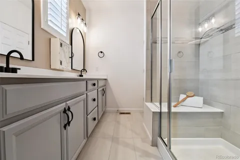 a bathroom with a double vanity sink a mirror and a shower