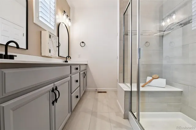 a bathroom with a double vanity sink a mirror and a shower