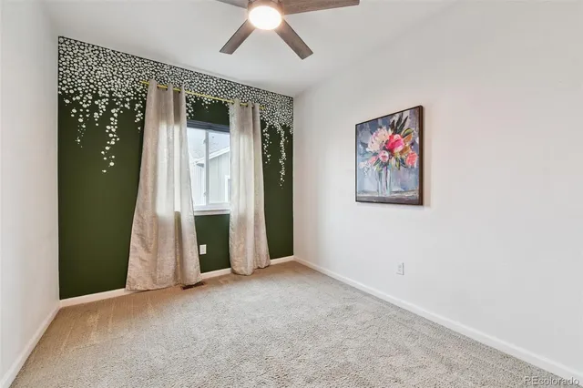 an empty room with a fireplace and fan