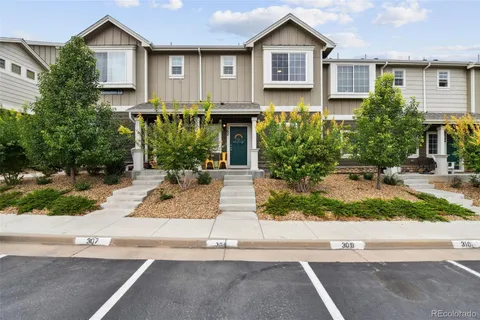 front view of house with a bench and trees