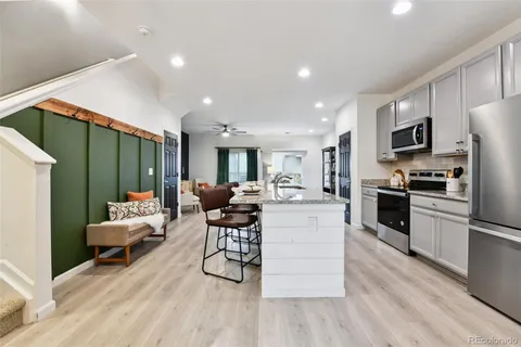 a kitchen with stainless steel appliances kitchen island granite countertop a stove a sink a refrigerator and a microwave